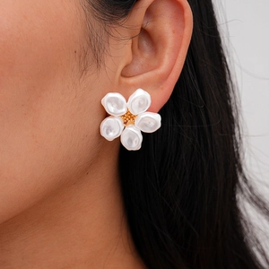 Detail of elegant five-petal flower stud earring with pearls and gold center on ear