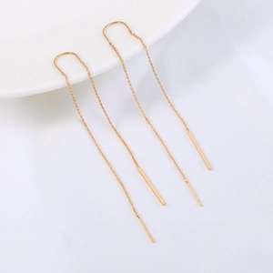 Detailed macro view of gold tassel ear threads with sparkling zircon stars and moon pendants