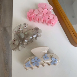 Three medium acetate hair claws featuring pastel 3D flowers and butterfly with crystal accents