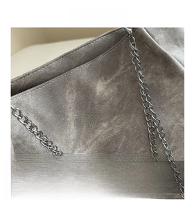 Detail of grey washed fabric tote bag featuring vintage canvas texture and silver metal chain