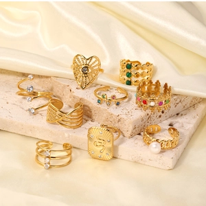 Detail shot of vintage gold rings with zircon and pearls on stone and silk