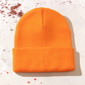 Detail der leuchtend orangefarbenen Rippstrickmütze mit Textur und gerolltem Randdesign