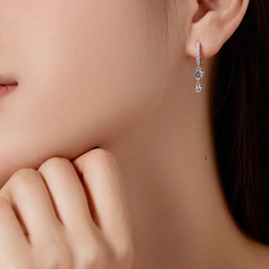 Detailed close-up of S925 sterling silver drop earrings with round cubic zirconia on model