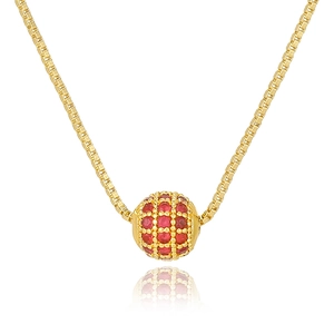 Detail of a gold box chain necklace featuring a brilliant red zircon pave spherical pendant