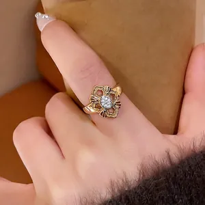 Elegant 24K gold plated hollow floral ring with tiny white crystals worn on hand