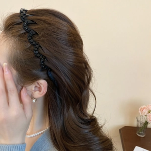 Detail of elegant black beaded wavy headband worn on hair with a vintage aesthetic