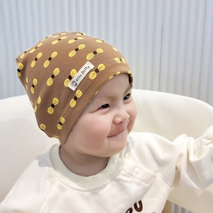 Close-up of baby knit beanie in brown with yellow insect print and brand woven label