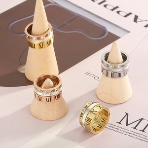 Detailed view of layered Roman numeral rings with shell inlay and cubic zirconia stones