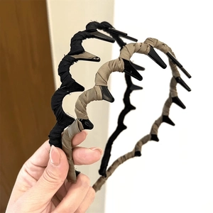 Close-up of wavy fabric headbands with teeth in black and khaki for hair styling