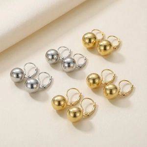 Detailed close-up of polished gold and silver spherical earrings with lever-back closures