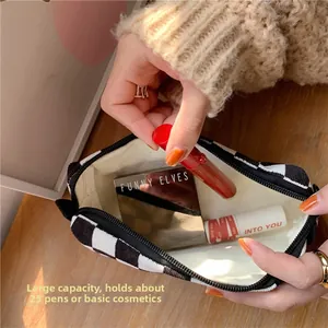 Detail of checkered knit cosmetic bag showing large interior capacity and zipper