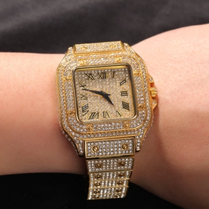 Macro view of gold square watch encrusted with rhinestones and black Roman numerals