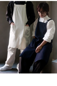 Detail view of cotton canvas aprons in beige and navy blue with adjustable straps