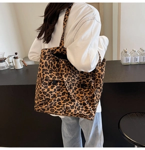 Detaillierte Seitenansicht der großen Canvas-Tragetasche mit Leopardenmuster im Café