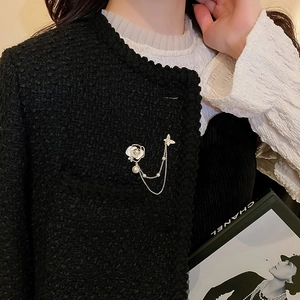 Détail de la broche fleur et papillon avec pampilles en perles sur veste en tweed