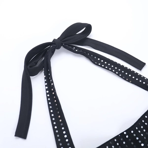 Détail du lien de cou noir avec paillettes argentées sur une barboteuse ajustée