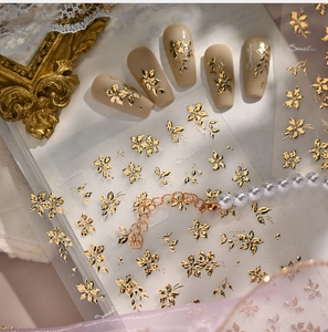 Detail of vintage gold floral nail stickers with intricate leaf patterns on matte nails