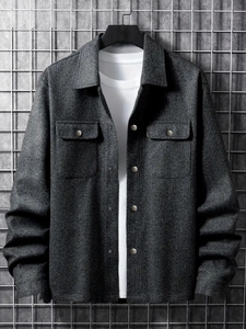 Macro detail of dark grey textured jacket with silver metal snaps and chest pockets