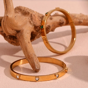 Detail of 18K gold plated stainless steel bangles with heart-shaped zircon stones