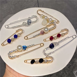 Luxurious gold and silver decorative safety pins set with pearls and colorful rhinestones