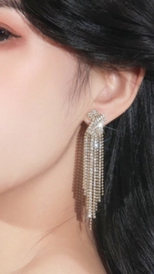 Close-up of elegant silver long tassel earrings with sparkling cubic zirconia on model