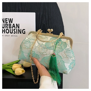 Detail of light green floral jacquard handbag with golden clasp and long green tassel