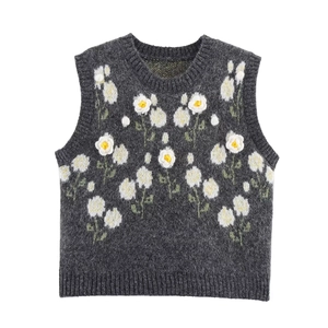 Dark grey knitted vest with white and yellow daisy flower embroidery on plain background