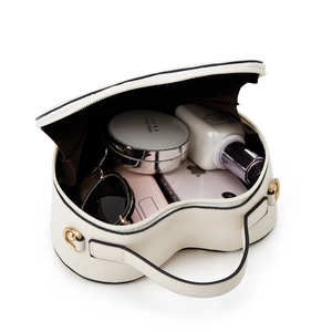 Interior storage space of heart-shaped handbag with cosmetics and smartphone