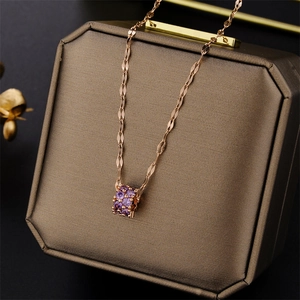 Rose gold necklace with a cylindrical pendant featuring sparkling purple zircon on a jewelry box
