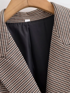 Vue rapprochée du blazer en laine pied-de-poule avec revers classique et tissu texturé