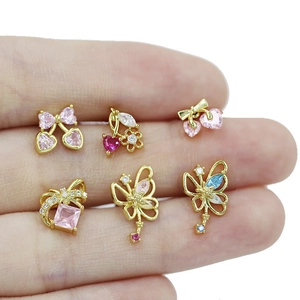 Collection of golden bow and heart shaped lip studs with pink and red zircon stones