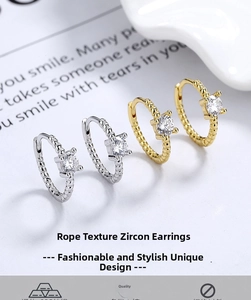 Detailed view of silver and gold rope twist hoop earrings with square zircon stone