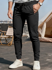 Detail of men's athletic joggers featuring drawstring waist and secure zipper pockets