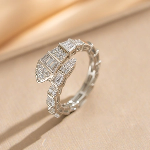 Snake shaped silver ring with sparkling cubic zirconia crystals on satin background