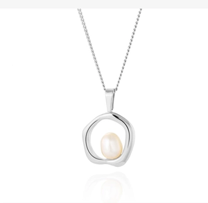 Macro shot of silver-tone irregular circle pendant with a lustrous white pearl on chain