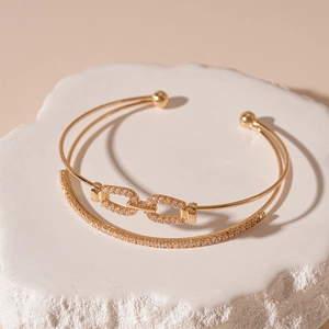 Detailed macro view of gold-plated double-layer bangle with pavé-set cubic zirconia accents