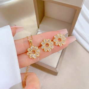Luxurious gold flower jewelry set with sparkling crystals in a beige jewelry gift box