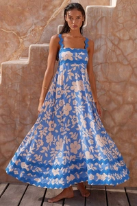 Detail of blue printed sundress with scalloped trim and white floral pattern