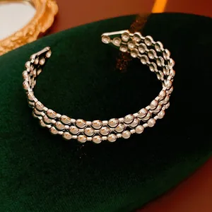 Bracciale a tre strati con perline d'argento su supporto in velluto verde scuro