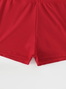 Detailed close-up of red tankini swimming shorts with premium double-stitch seams