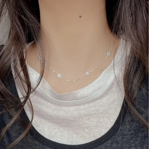 Close-up of 925 sterling silver daisy flower choker necklace worn on model neck