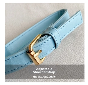 Detail of adjustable light blue leather shoulder strap with polished gold metal buckle