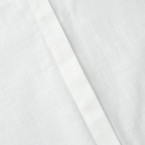 Macro view of white linen-textured fabric with detailed hem stitching and weave texture
