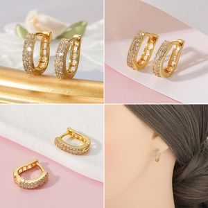 Primer plano de pendientes en forma de U bañados en oro de 18K con filas de circonitas