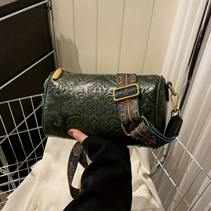 Detail of vintage green floral embossed cylinder bag with wide jacquard shoulder strap