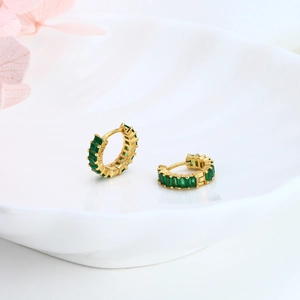 Detail of gold S925 silver earrings with green rectangular zircon in ceramic dish