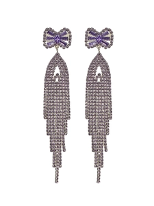 Macro shot of long purple tassel earrings with zircon bowknot and flowing diamond chains