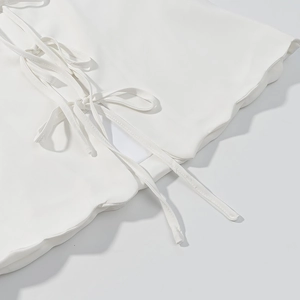 Détail du design à lacets blancs et de la texture fluide du tissu de l'ensemble