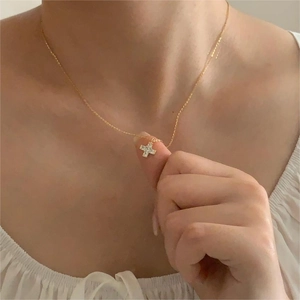 Elegant 925 sterling silver gold cross necklace with sparkling cubic zirconia on model