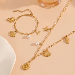 Detailed macro view of gold stainless steel shell and starfish charms with pearls